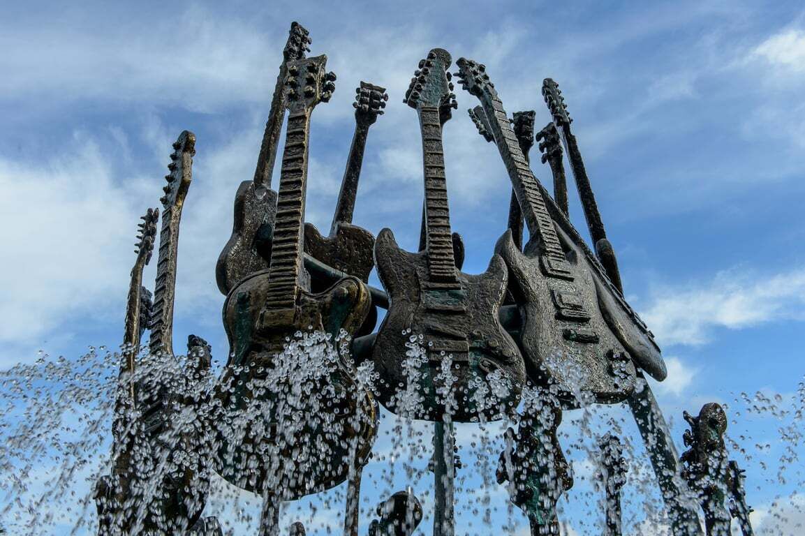 A sculpture of guitars with water flowing from them.