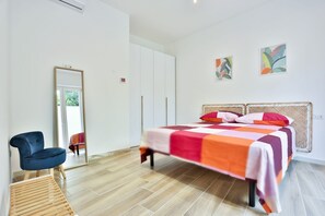 Une chambre à coucher avec un lit, une chaise, une armoire et un miroir.
