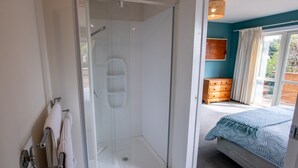 Un dormitorio con cama, ducha y vistas al exterior.