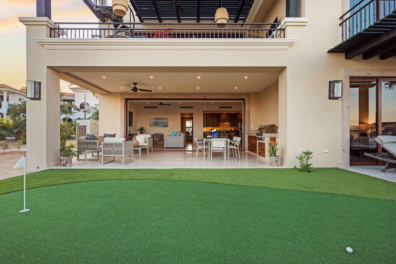 Une maison moderne dotée d’un patio couvert, d’un coin repas et d’un salon.