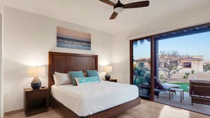 A bedroom with a large bed, two bedside tables with lamps, a ceiling fan, and a view of a pool and outdoor area. - Beautiful Golf or Family Luxury Villas Dunes 1913 (Palmilla)