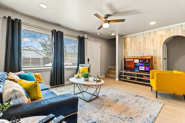 A modern living room with a sofa, armchair, and a television.