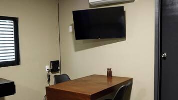 Habitación individual básica | Área de sala de estar | Smart TV de 32 pulgadas con canales digitales y monitor de computadora