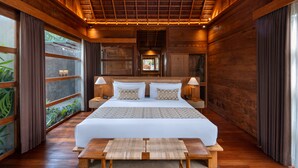 A spacious bedroom with a large bed, wooden walls, and a ceiling with wooden beams. - Unagi Wooden Villa by Emana (Ubud)