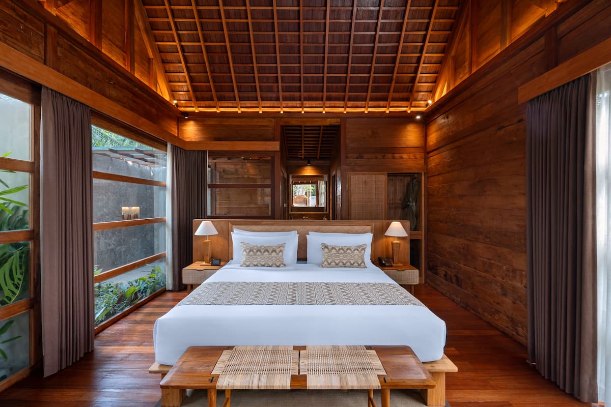 Ein geräumiges Schlafzimmer mit einem großen Bett, Holzwänden und einer Decke mit Holzbalken.