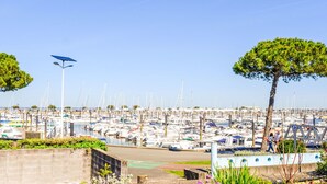 A marina with numerous boats docked, a clear sky, and a few people walking. - Pleine Mer by Interhome (Arcachon)