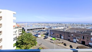 A marina with numerous boats, a parking lot, and buildings in the foreground. - Port Arcachon by Interhome (Arcachon)