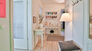 A hallway with a white desk, a lamp, and a small plant. - Ocean Breeze No.6 - Idealer Ostsee-urlaub: Neue Traumwohnung in Strandnähe (Timmendorfer Strand)