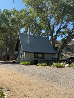 A single-story building with a sloped roof, a chimney, and a satellite dish.