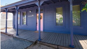 Een gebouw met twee verdiepingen, een blauwe gevel en een houten terras.