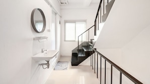 A modern bathroom with a sink, mirror, and window. - Roombix CityHouse -CozyHouse Near Bts for 12 ppl - RB4 (Krung Thep Maha Nakhon)