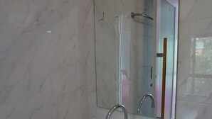 A bathroom with a white sink, a mirror, and a shower door.