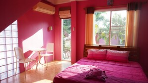 A pink-themed room with a bed, a chair, a small table, and a window with curtains. - Ban Rai Rabeangmok (Khao Kho)
