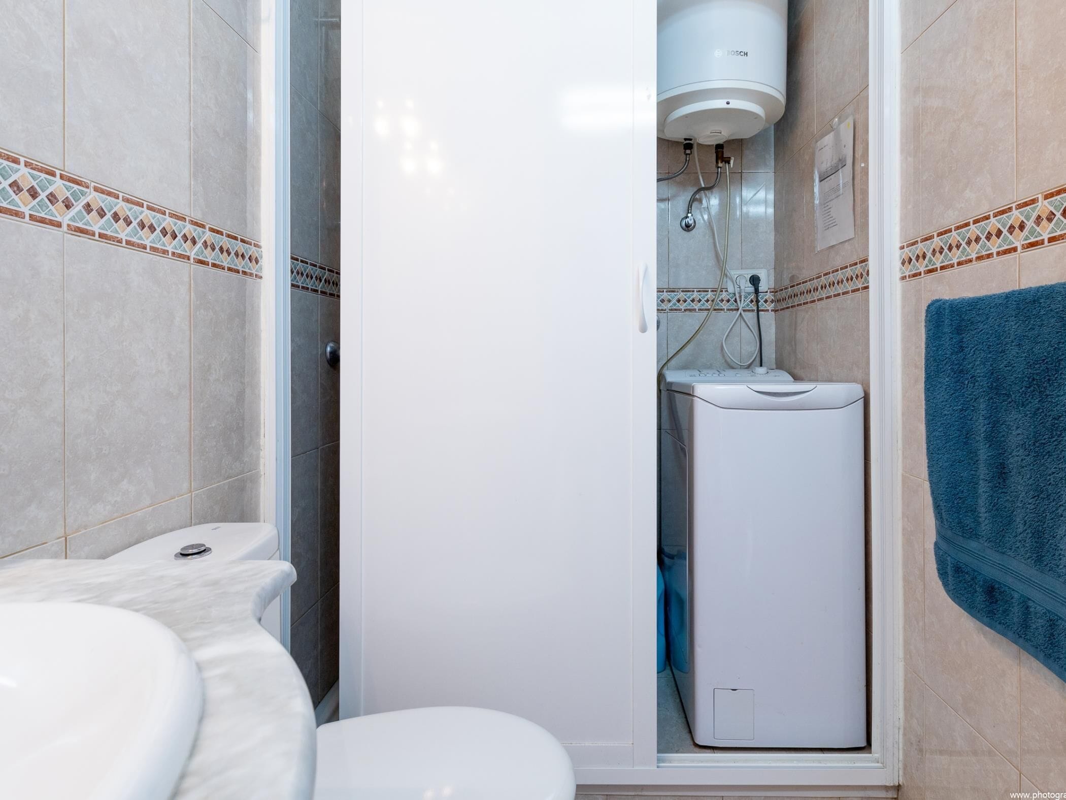 A bathroom with a toilet, a sink, and a shower enclosure.