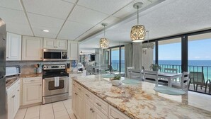 A modern kitchen with a marble countertop, stainless steel appliances, and pendant lighting. - Edgewater T2 #911- 2 BR + Hall Bunks! (Panama City Beach)