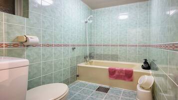 Un baño con inodoro, bañera y ducha.