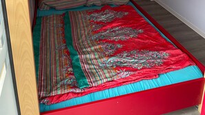 A bunk bed with a red frame and a lower bed with a colorful, patterned bedspread. - Boat 'Hausboot Explorer' with Lake View and Private Terrace (Schwerin)