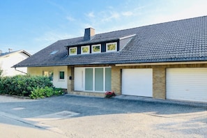 A residential house with a sloped roof, a garage, and a front door.