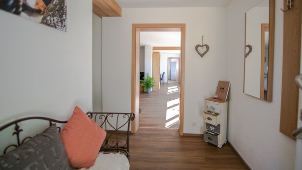 Une chambre à coucher comprenant un lit, une commode, un miroir et un couloir menant à une autre pièce.
