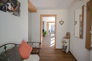 Un dormitorio con cama, cómoda, espejo y un pasillo que da a otra habitación.