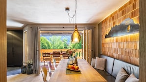 Un espace repas avec une table en bois, des bancs et un luminaire suspendu.