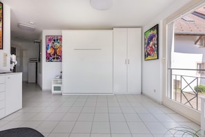 Une pièce spacieuse avec une grande armoire, un coin cuisine et un balcon avec vue.