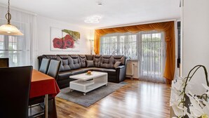 A modern living room with a sectional sofa, a dining table with chairs, and a coffee table. - Apartment Ahorn with Private Terrace and Wi-Fi (Waldshut-Tiengen)