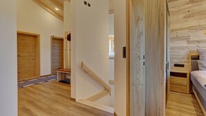 A wooden interior with a staircase, a bed, and a small bedside table. - Chalet 'Landhaus Rachelblick' with Mountain View, Private Terrace and Wi-Fi (Eppenschlag)