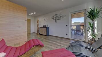 A room with a wooden slat wall, a word cloud mural, a wooden cabinet, and a view through a glass door.