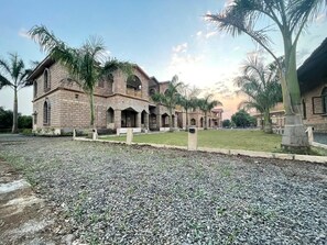 Un edificio grande con múltiples ventanales arqueados y un patio central.
