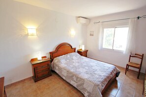 Cozy bedroom with a comfortable bed, bedside tables, and a chair near the window.