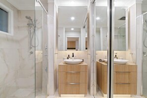 A modern bathroom with a glass-enclosed shower, a wooden vanity with a sink, and a mirror above the vanity. - Urban Sanctuary! 1Bed, 1Bath, 1Car, POOL~Teneriffe (Teneriffe)
