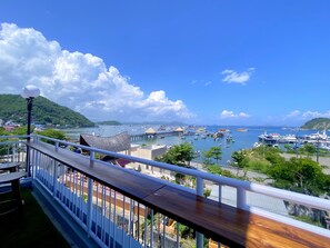 A balcony with a view of a marina, boats, and a pier. - Flamingo Ceria (Labuan Bajo)