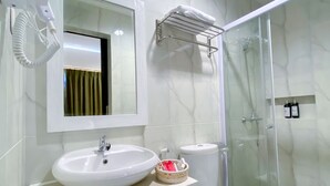 A modern bathroom with a white sink, mirror, and toilet. - Flamingo Ceria (Labuan Bajo)