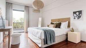 A modern bedroom with a large bed, a bedside table, a nightstand, a hanging light fixture, and a window with curtains. - Chic & Luminous 3BR Apartment in Kifisia (Kifisia)