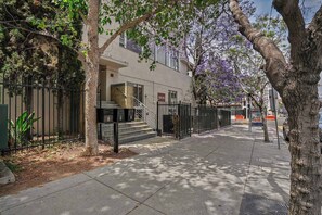 A residential building with a gated entrance, a staircase leading to the entrance, and a sidewalk in front. - Chic Urban Loft in the Heart of Little Italy (San Diego)