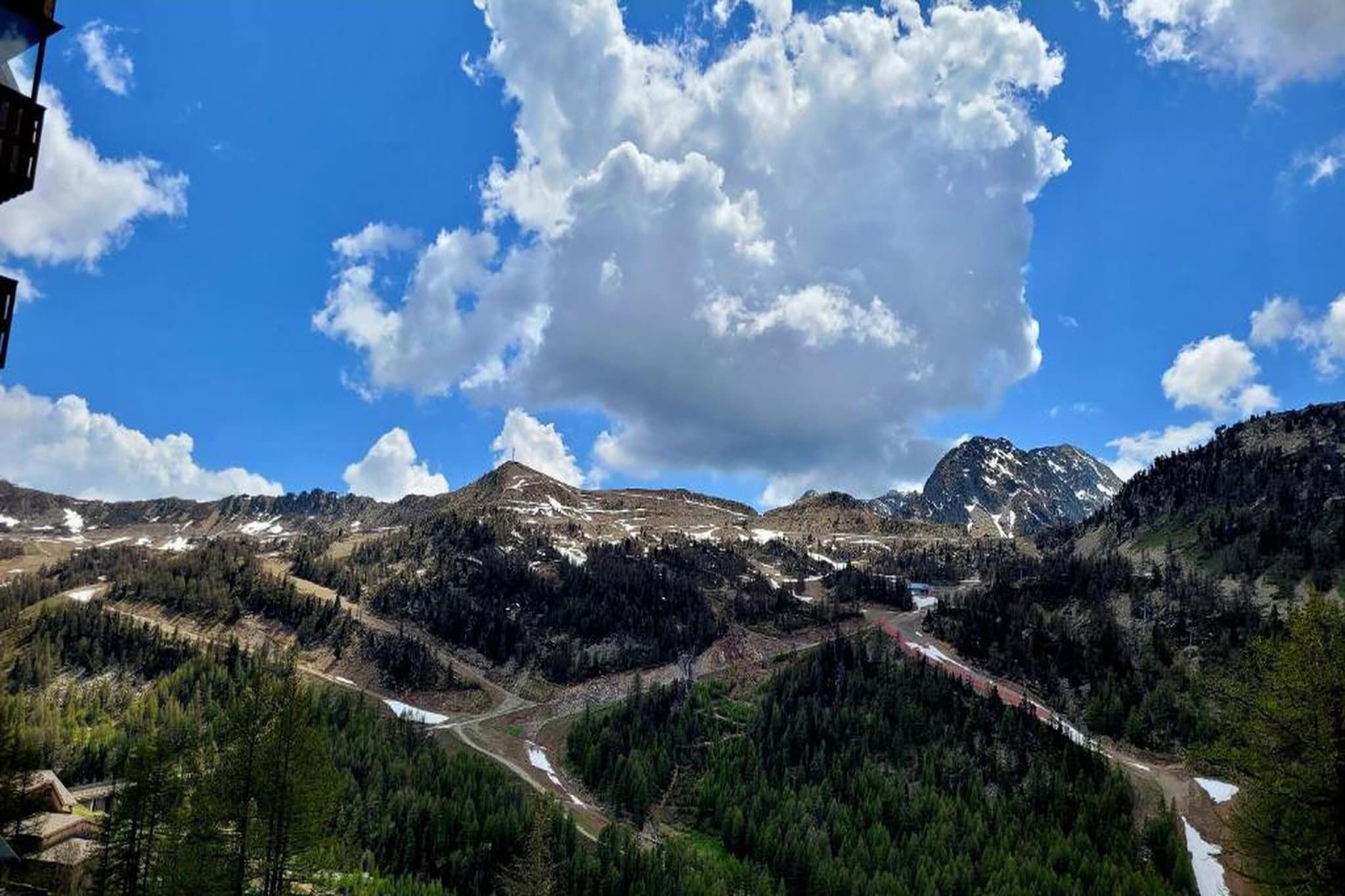 A mountainous landscape with a clear sky and a prominent cloud formation.