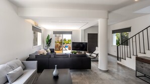 Un salon moderne avec un canapé, une table basse et un téléviseur.