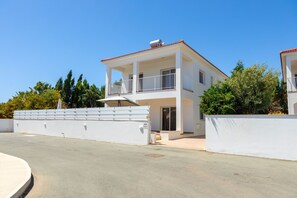 A two-story building with a balcony, a white exterior, and a clear sky. - Napa Bay View Villa 7 (Ayia Napa)