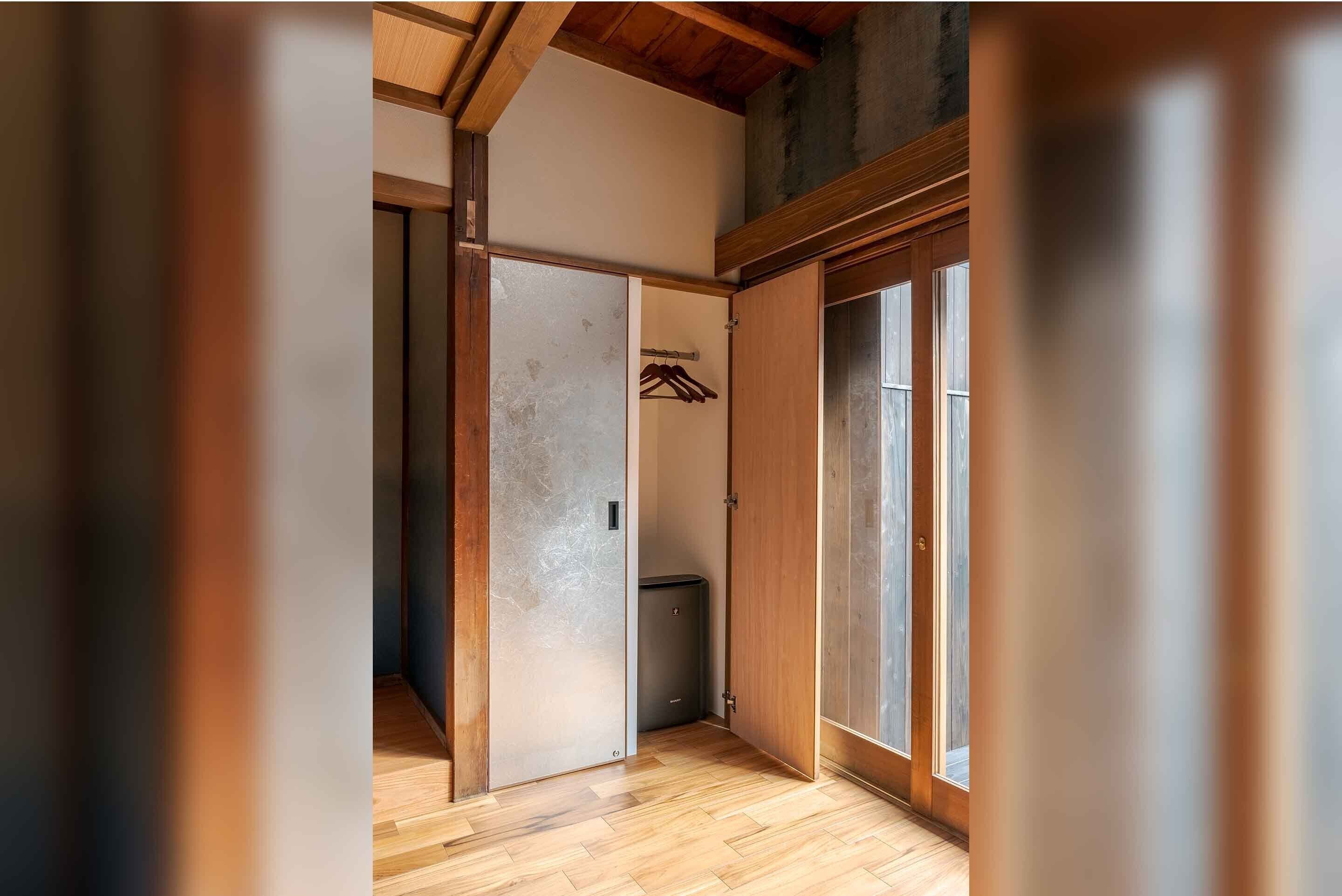 Une pièce avec un plancher en bois, une porte coulissante et une fenêtre.