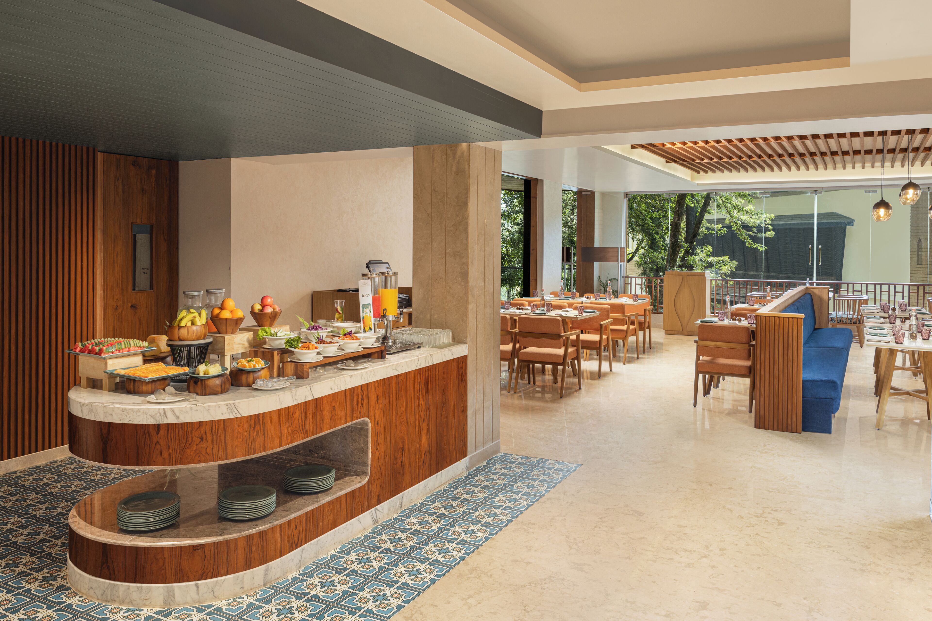 A modern dining area with a buffet setup, wooden accents, and a view of the outdoors.