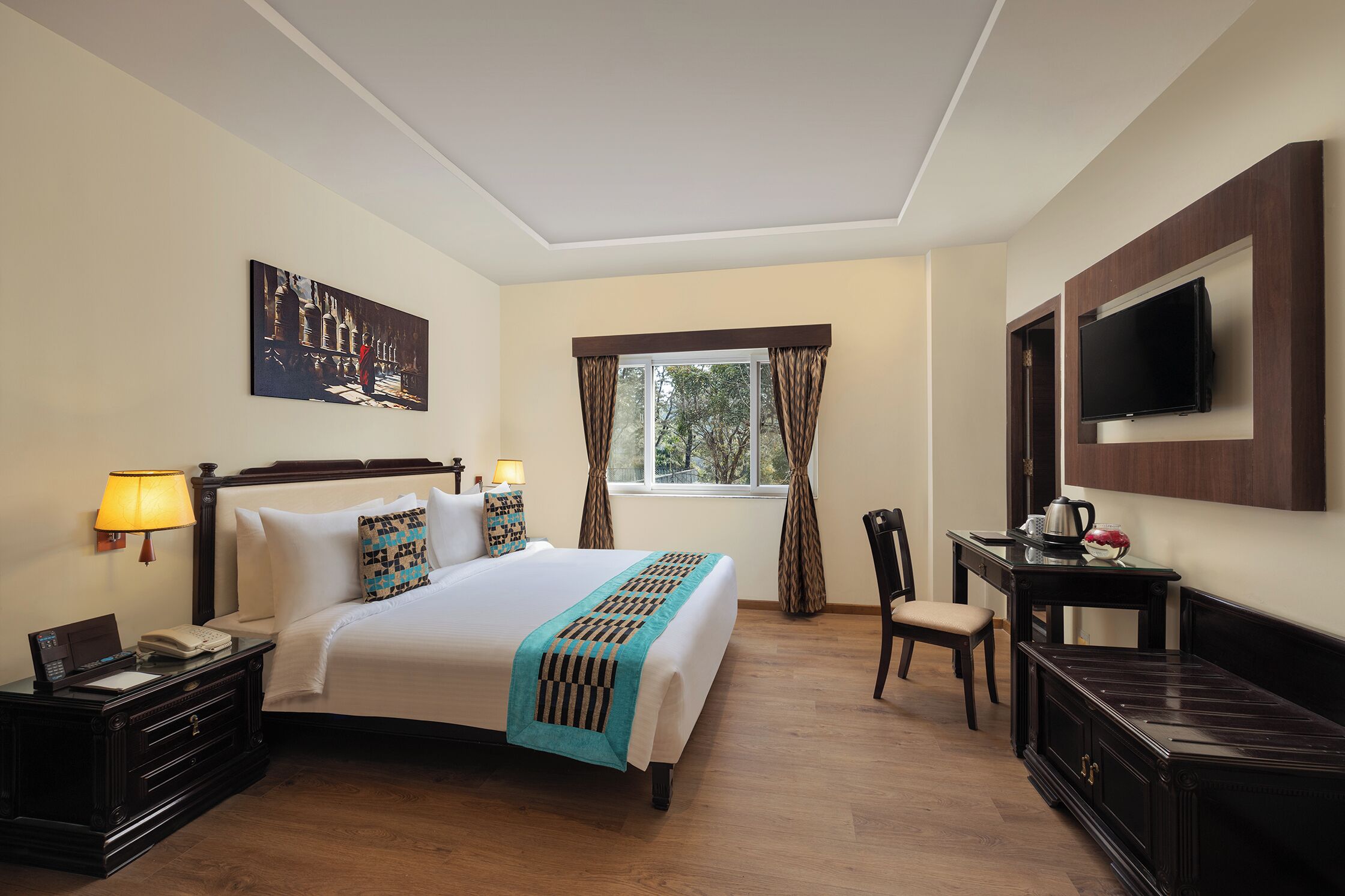 Habitación de hotel con cama, mesita de noche, lámpara, televisor y ventana con cortinas.