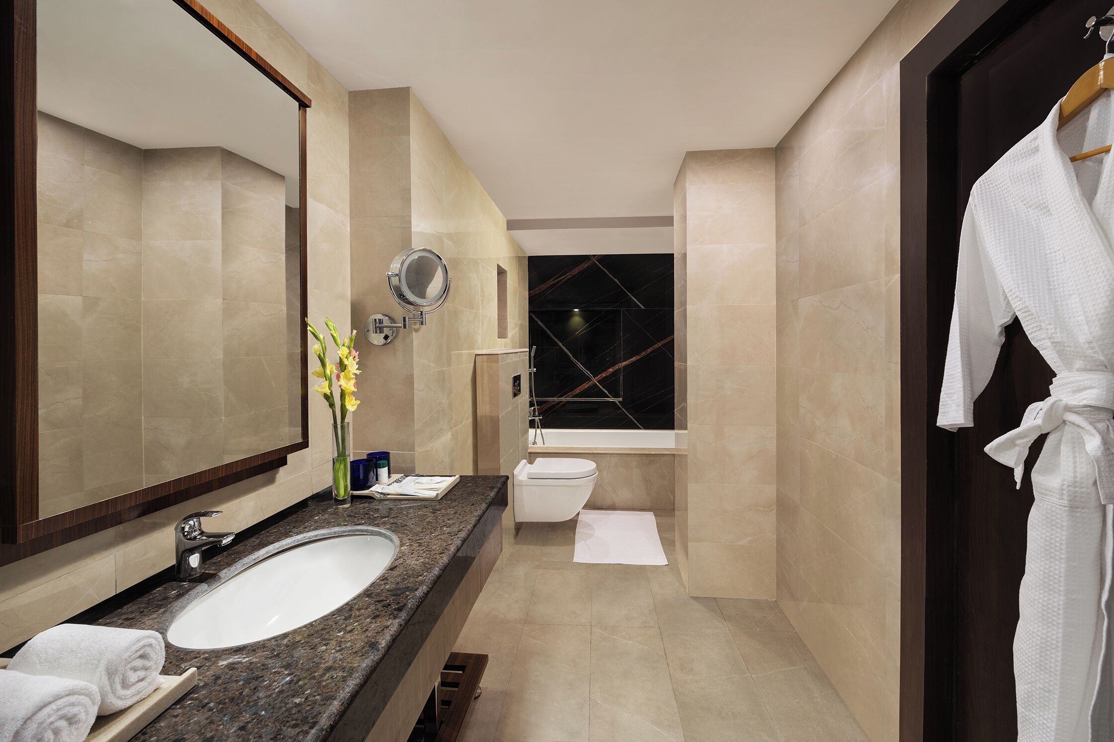 A modern bathroom with a large sink, mirror, and a bathtub.