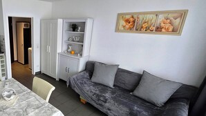 A compact living space with a sofa, a dining table, and a kitchenette. - Ruhige Ferienwohnung/ Amateurzimmer/ Gute Verkehrsanbindung (Linden)