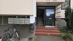 A building entrance with a mailbox, a bicycle, and a staircase leading to the entrance. - Ruhige Ferienwohnung/ Amateurzimmer/ Gute Verkehrsanbindung (Linden)