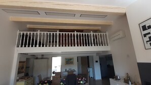 Ein Wohnbereich auf zwei Etagen mit Balkon, Kamin und einem Bild an der Wand.