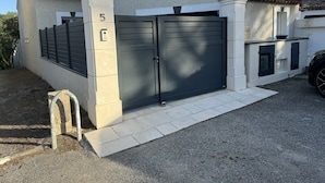 Ein modernes Haus mit grauer Garagentür, einem Briefkasten und der Hausnummer 5 an der Wand.
