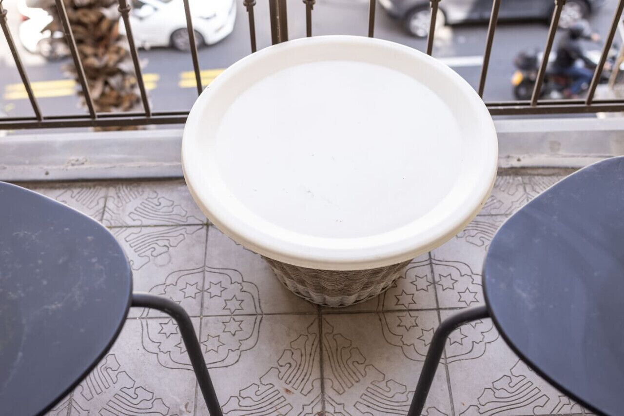 A tiled floor with a white circular object in the center, surrounded by chairs.