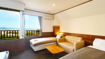 A hotel room with a balcony, a bed, a sofa, and a small table.