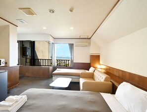 Une chambre d’hôtel avec un lit, un canapé, une petite table et un balcon avec vue.
